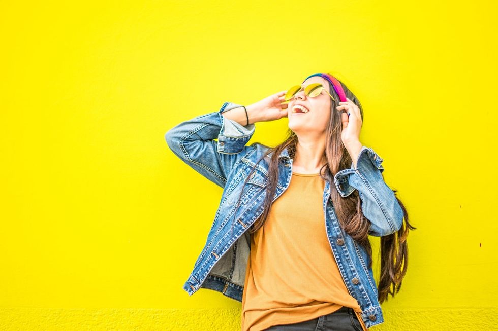 https://www.pexels.com/photo/smiling-woman-looking-upright-standing-against-yellow-wall-1536619/