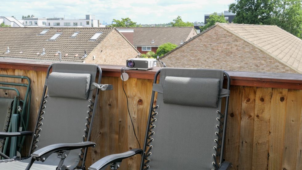 Photo of an Apeman projector being used on a roof terrace