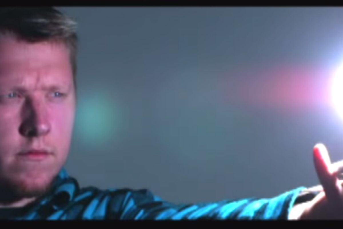 a man holds out his arm toward a ball of light