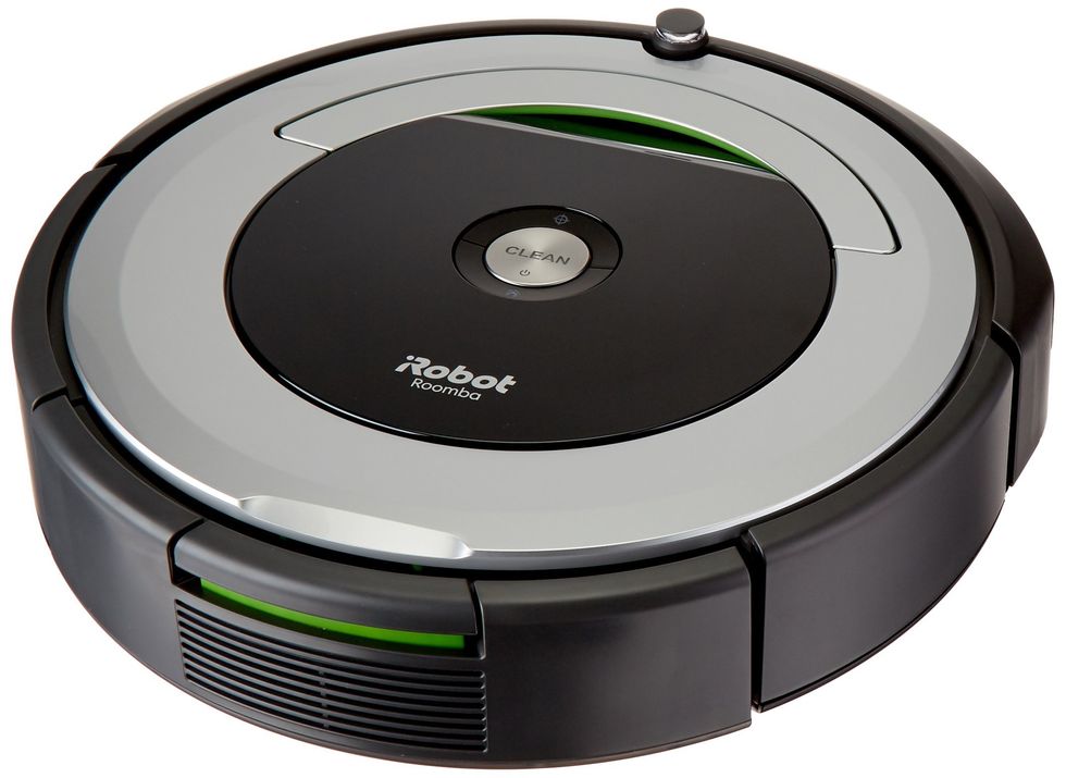 A photo of the iRobot Roomba 690, with a round shape in black, with a silver top, with the words Clean and iRobot on the top