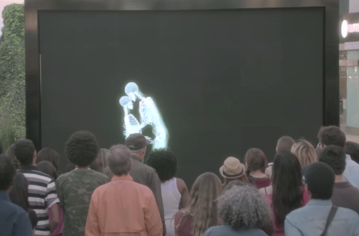 crowd watching embracing skeletons through screen