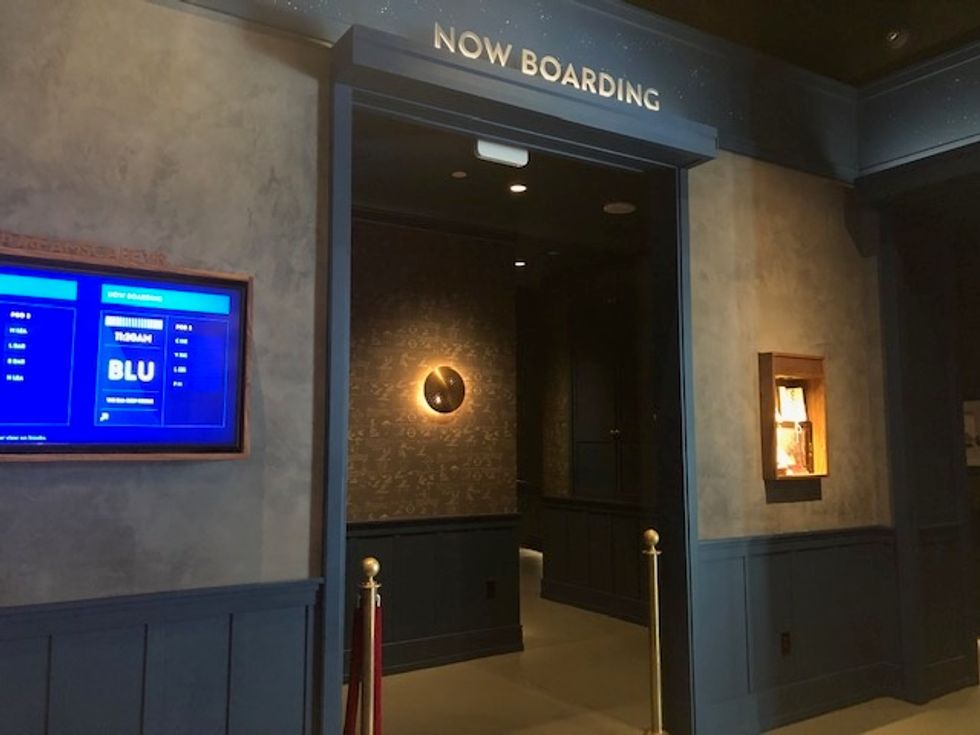 A doorway that says above, 'Now Boarding', leading to a darkened hallway