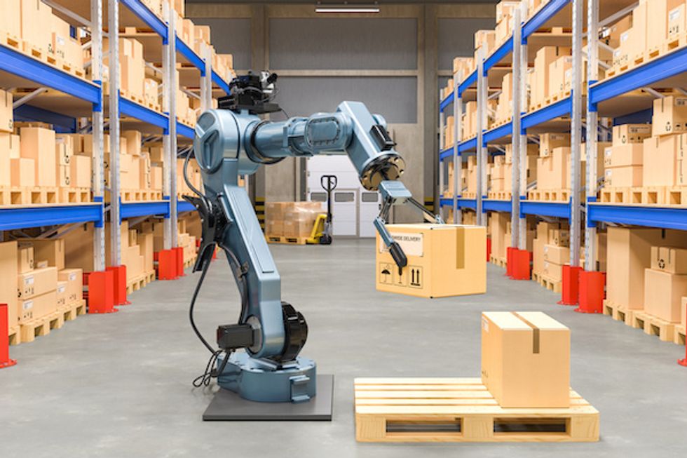 A robot holding a cardboard box inside a warehouse with floor to ceiling boxes