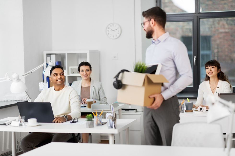 Professional man with a box of his belongings quitting his job