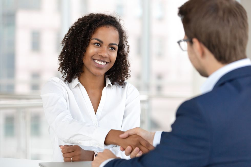 Woman shaking interviewer's hand during job interview
