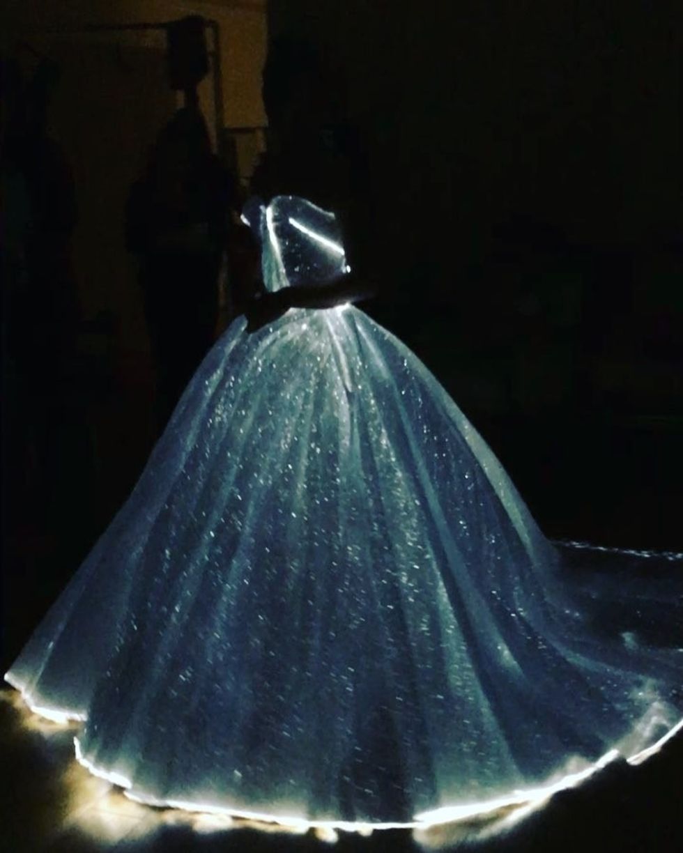 A blue and white gown lit with small fairy lights against a dark background