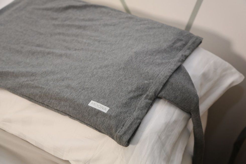 A gray fabric cover lying across a white pillow