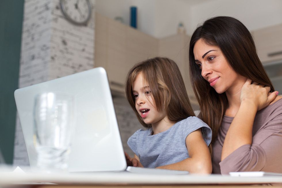 A\u00a0mother and daughter using a computer.