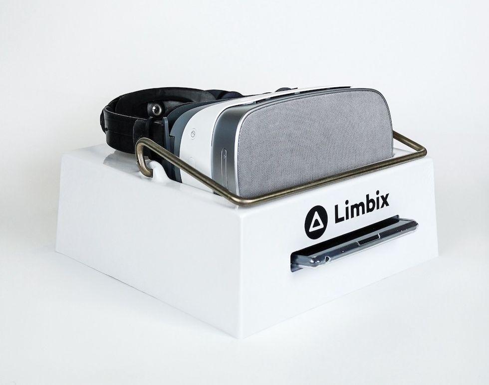 A virtual reality headset, with a gray screen, seated in a white box with the word "Limbix" across the front