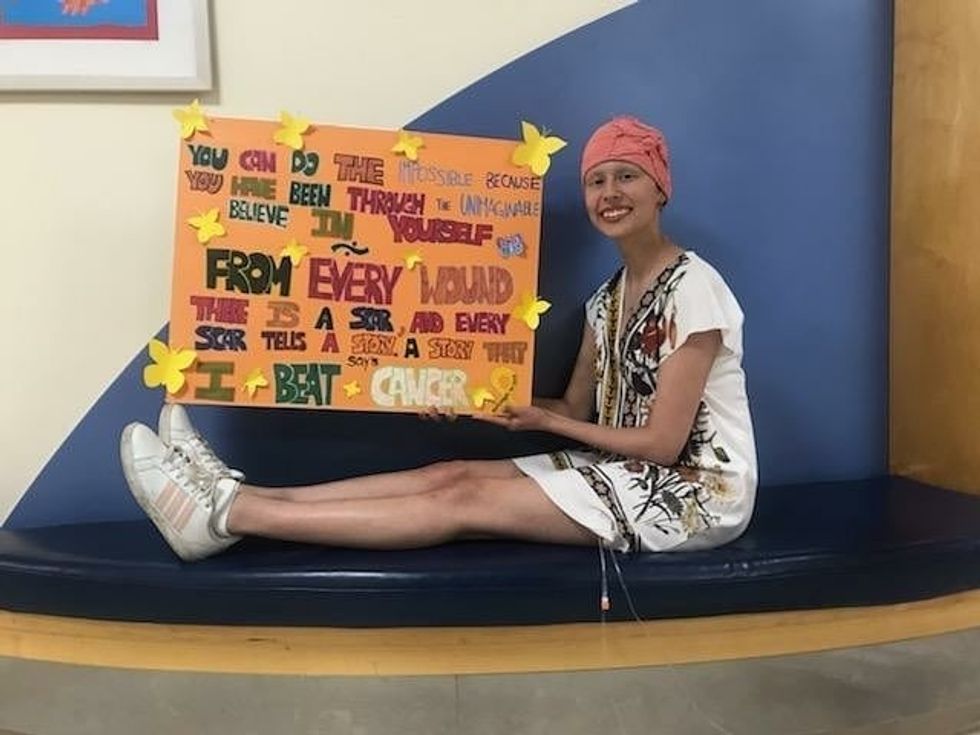 Chiara Valle, lors de son dernier jour de chimio, montre une affiche de texte inspirant qui se termine par «J'ai vaincu le cancer».