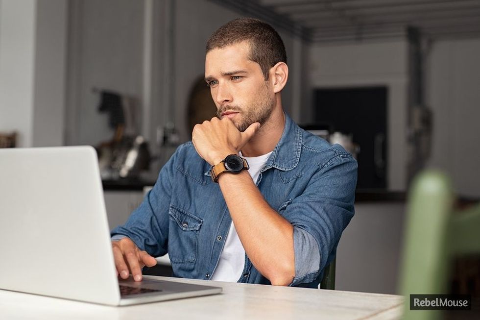 Young professional carefully looks over his LinkedIn profile.