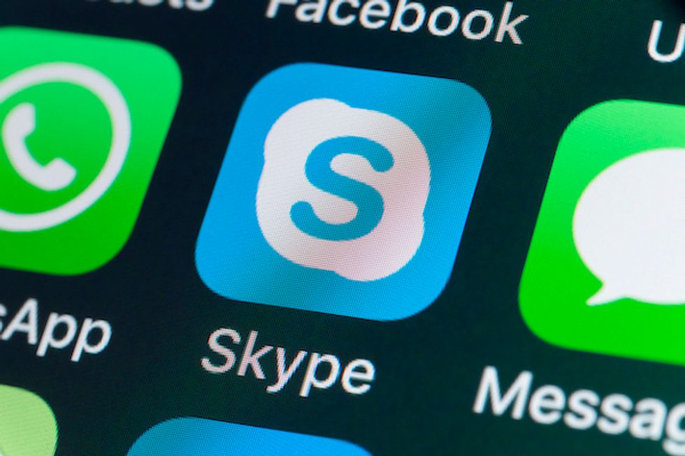 An icon for the Skype app, blue with a white cloud and a blue-colored letter 'S' in the middle