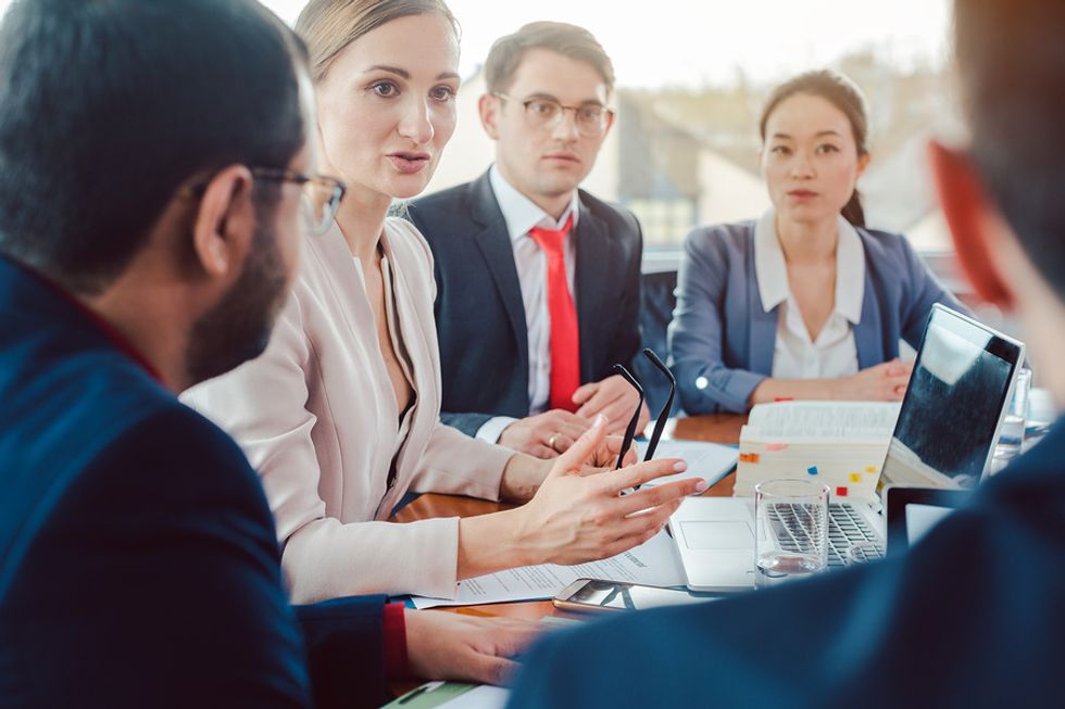 Manager addressing her team at a meeting in the office.