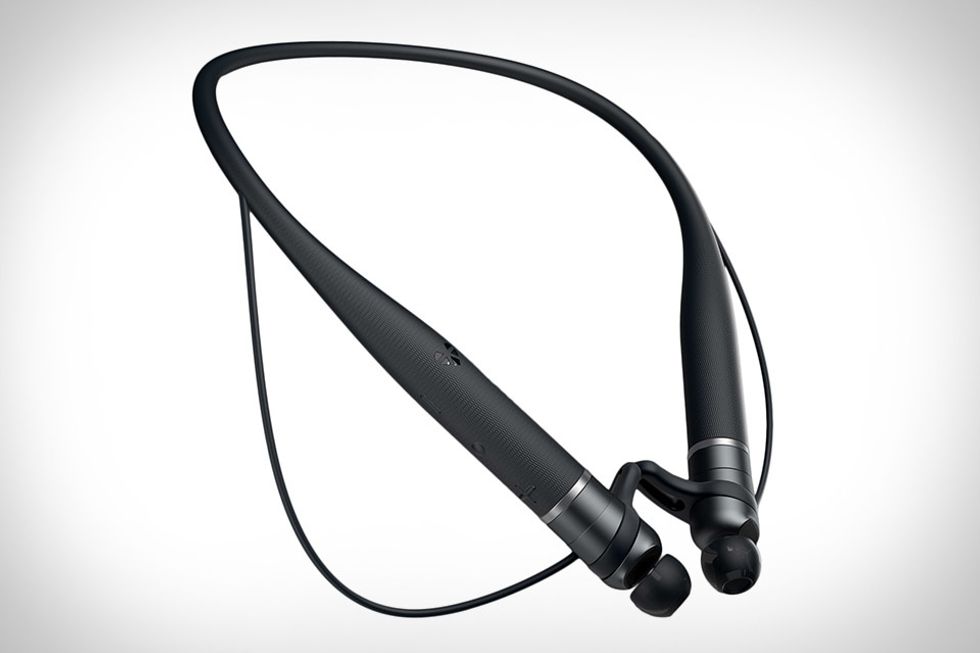 A pair of headphones that are black, thin, and connect in one loop in the back