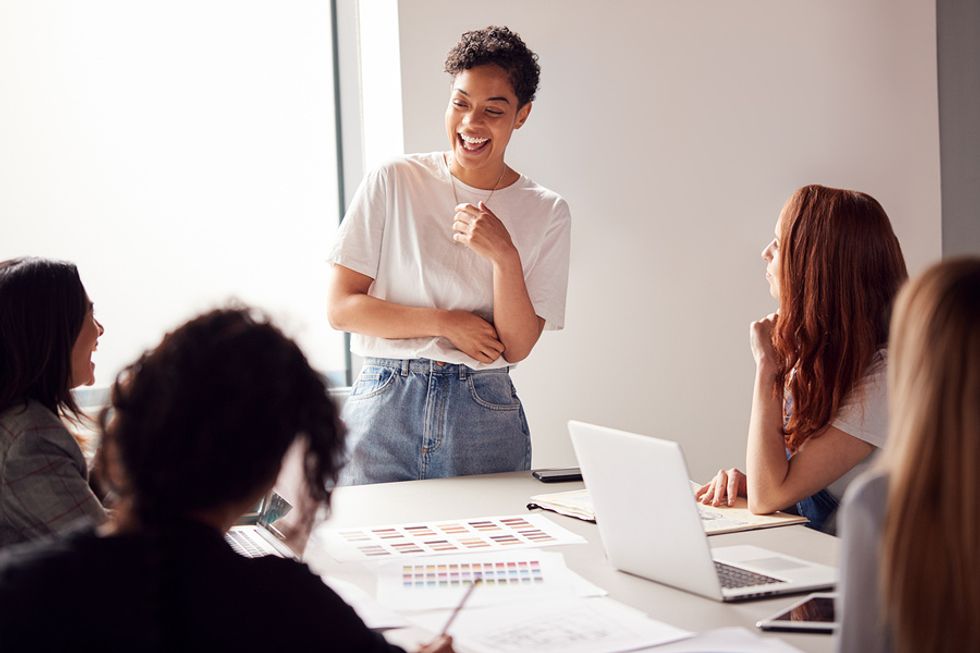 Female boss using her soft skills to effectively lead an office meeting.