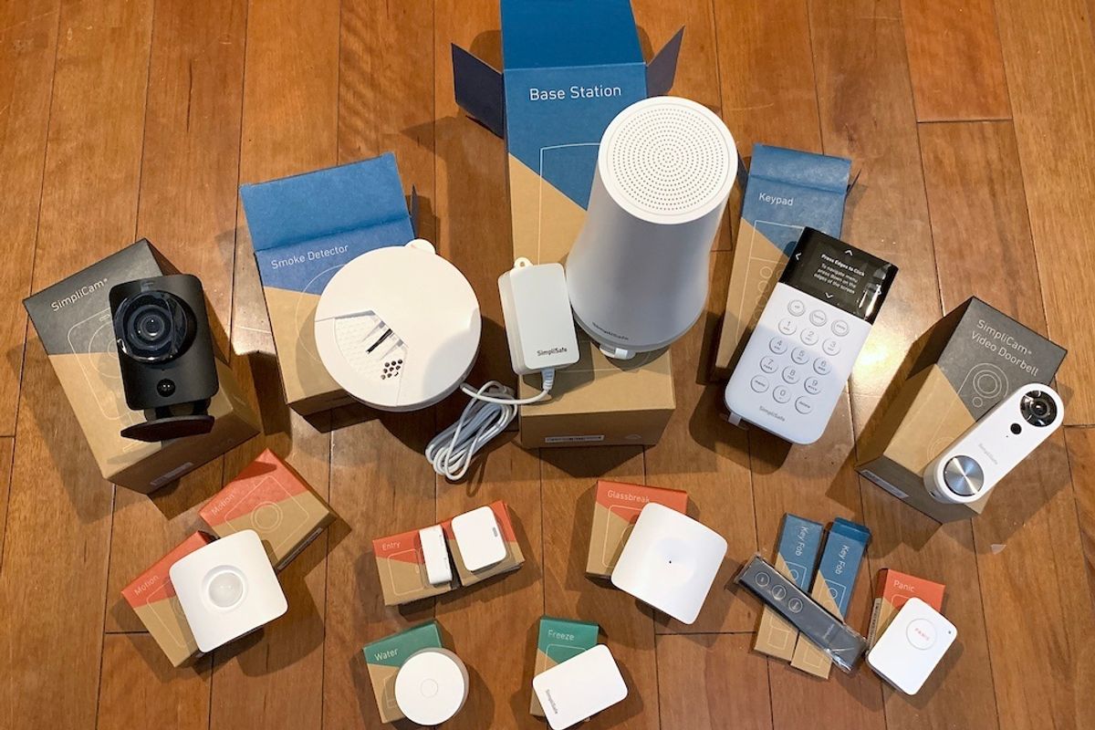 Devices on boxes on a wooden floor, including a key pad, sensors, a camera and wires