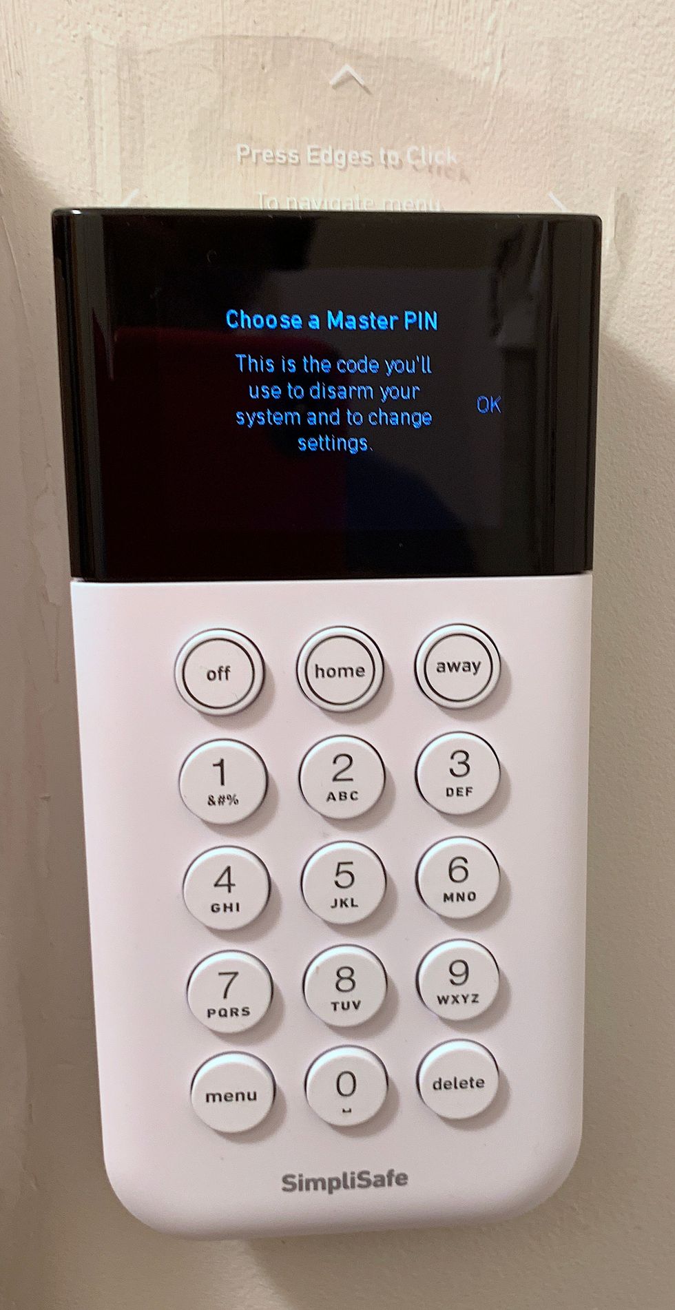 A white keypad with a digital screen at the top of it, and numbers along the bottom