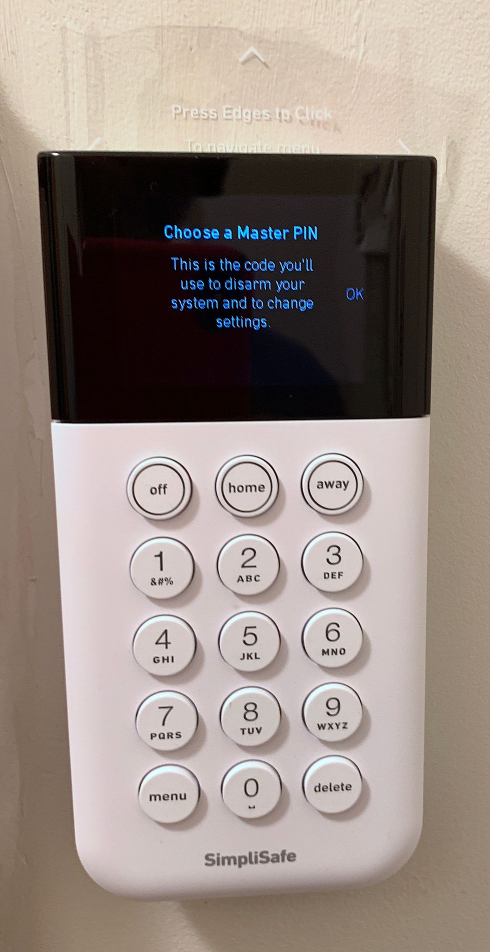 A white keypad with a digital screen at the top of it, and numbers along the bottom