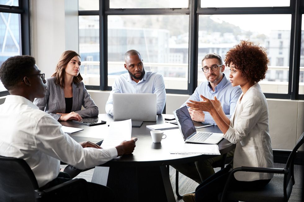 http://Woman sharpening her leadership skills by speaking up and sharing her opinion in an office meeting.
