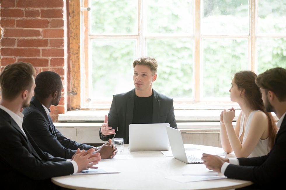 Man sharpening his leadership skills by delegating work to his team at work.