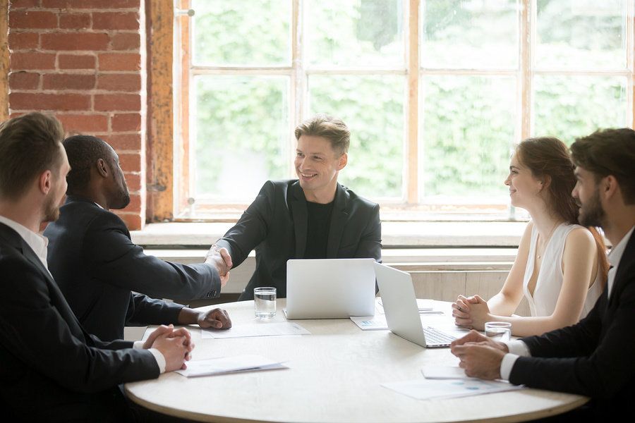 Male boss seeing a win-win situation in a team meeting at work.