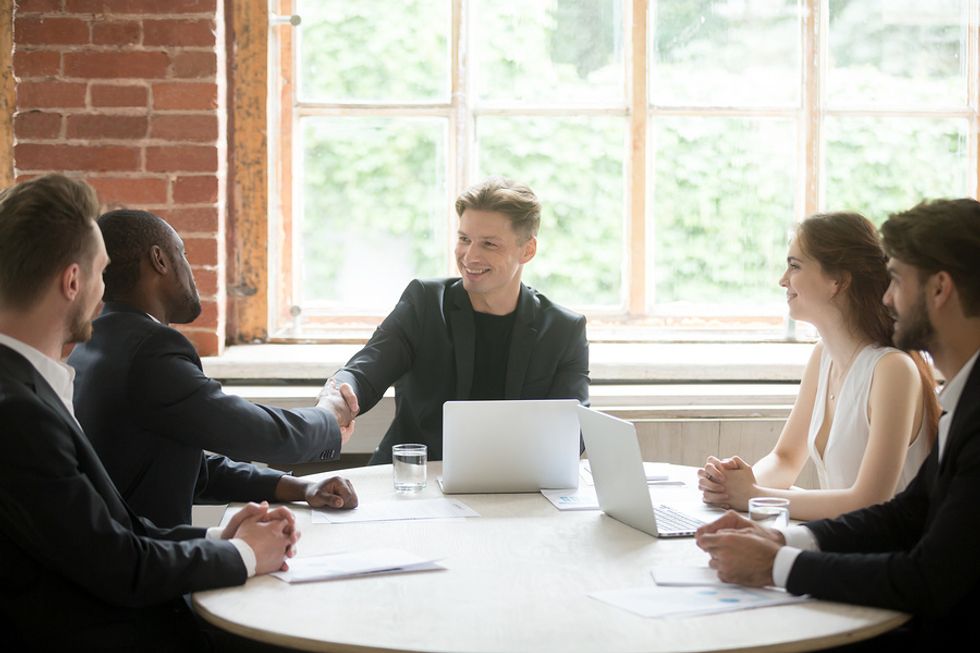 Male boss seeing a win-win situation in a team meeting at work.