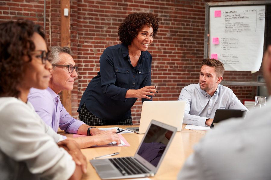 Female worker taking the lead and sharing what opportunities she sees at work during a team meeting.