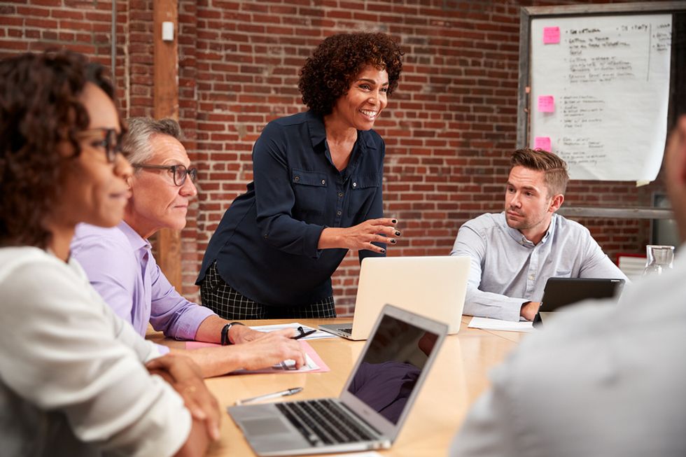 Female worker taking the lead and sharing what opportunities she sees at work during a team meeting.