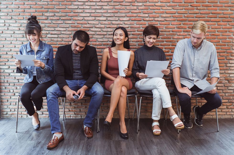 Multiple job candidates wait to be interviewed by employer.