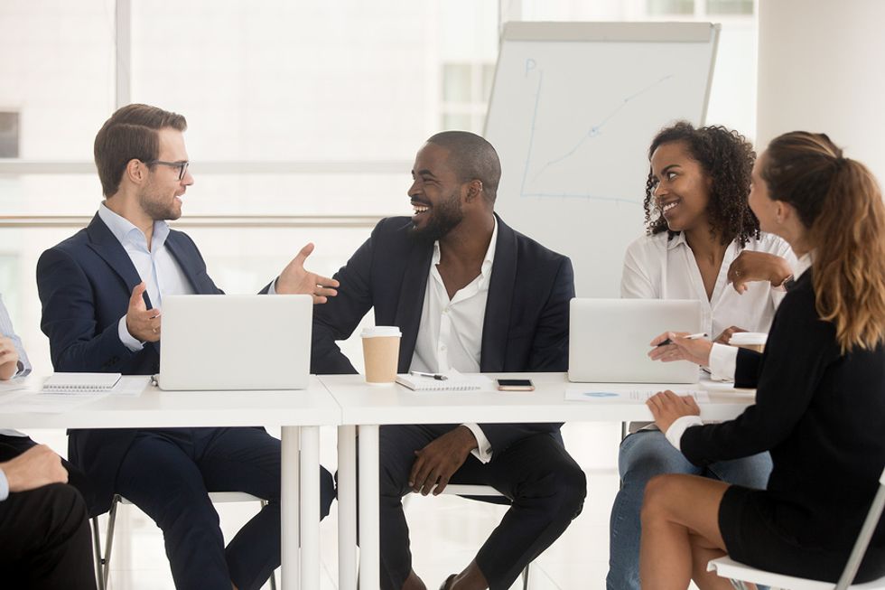 Male leader talking to his co-workers and using his personal leadership skills to motivate them and himself.