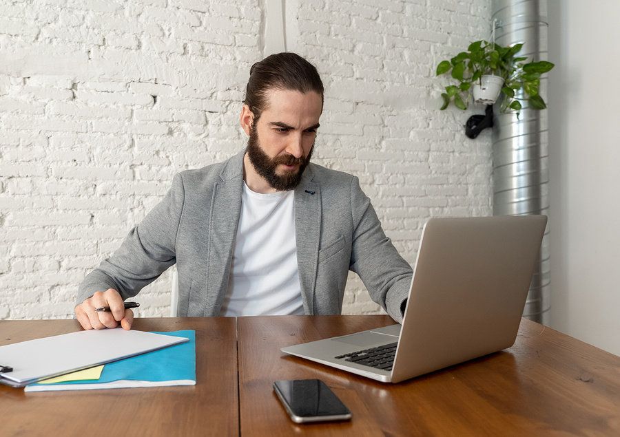 Man looking over his resume and formatting it to market his leadership skills.