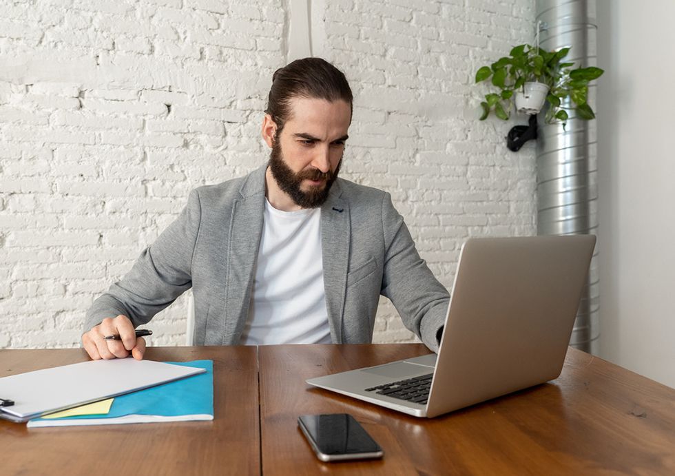 Man looking over his resume and formatting it to market his leadership skills.