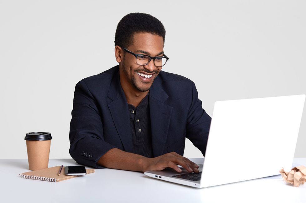 Smiling man working on his resume and tailoring it for a leadership job.