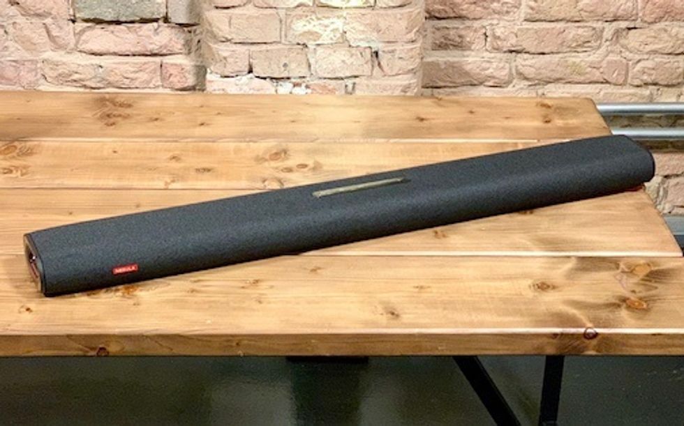A large black soundbar sitting on top of a wooden table