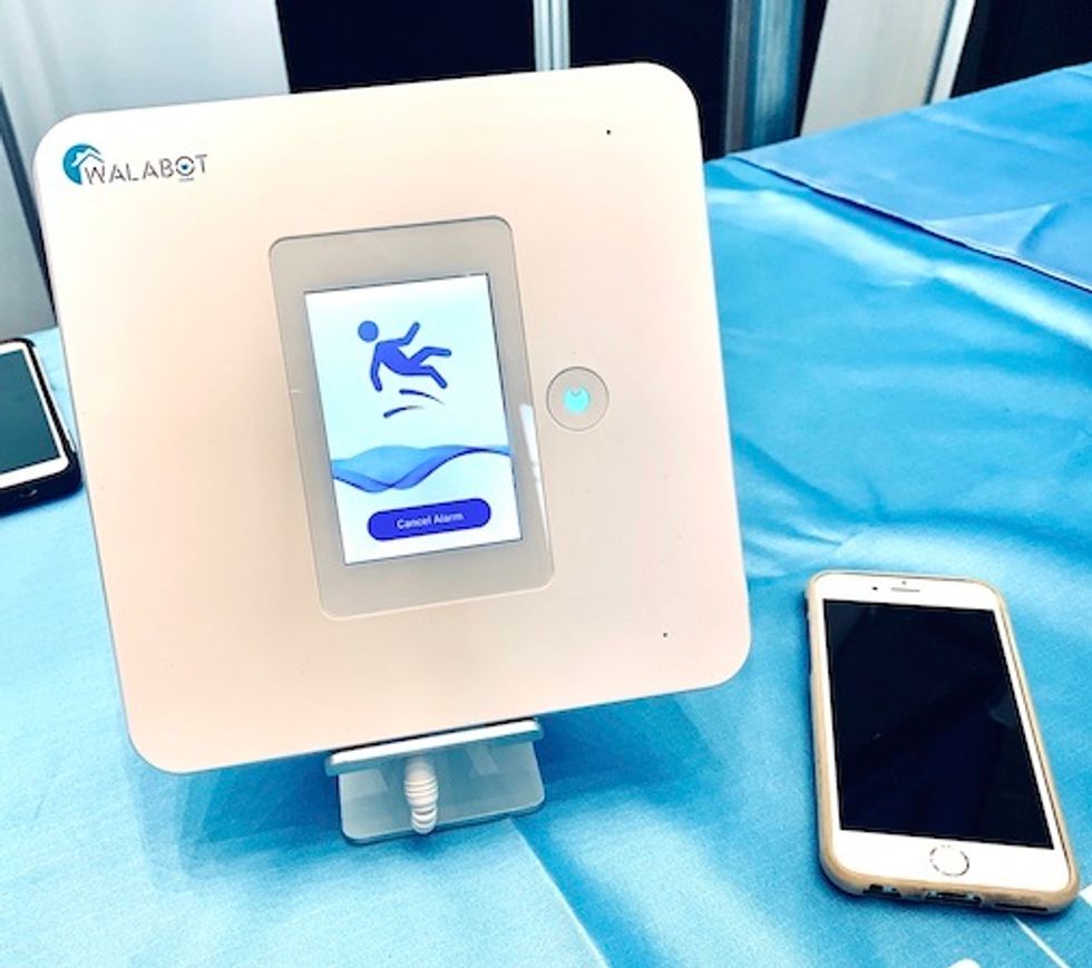 A white square device with an image of a person falling on a screen