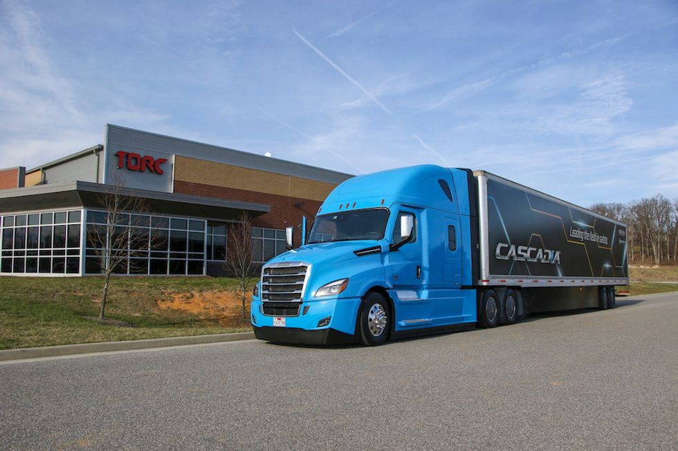 A blue semi-truck with the word, Cascadia on the side