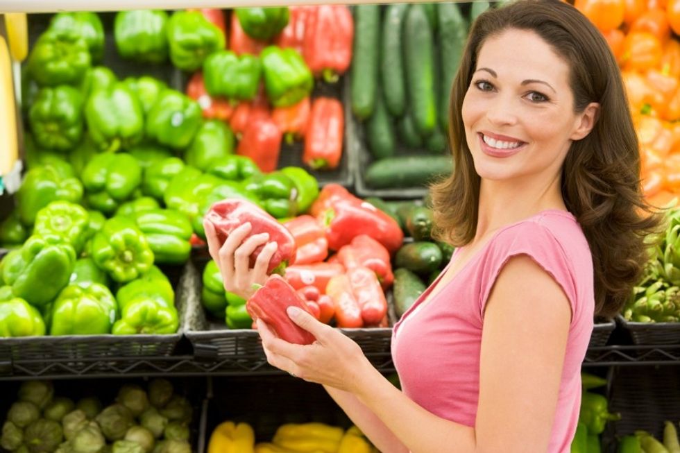 Woman picking out vegetables in order to eat them at work and feel happy in the workplace.
