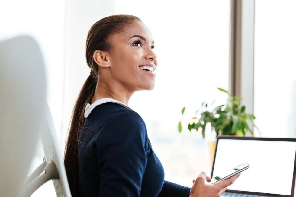 Young professional woman working at computer and happy at work because she loves her career.