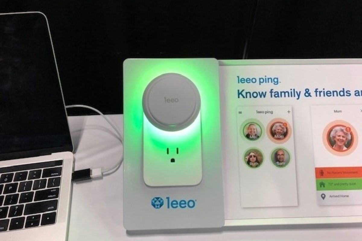 A smart device glowing green on a white table, with the name ‘leeo’