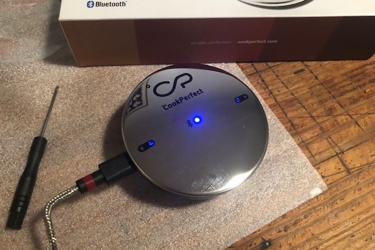 The CookPerfect, a silver round sensor with a meat thermometer attached by a wire
