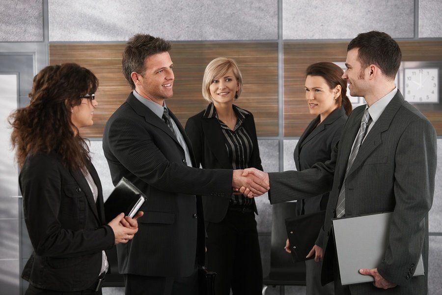 New male employee shaking hands with co-workers, introducing himself and getting their names.