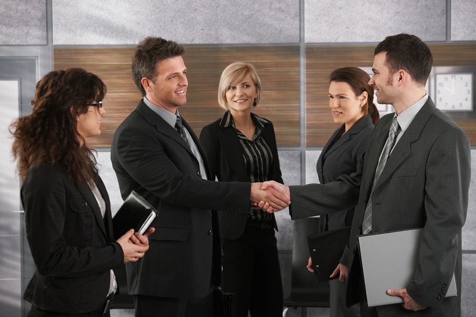 New male employee shaking hands with co-workers, introducing himself and getting their names.