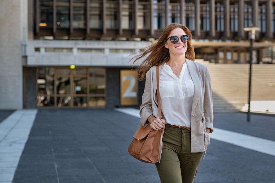 Smiling young female worker walking into work on her first day at a new office.