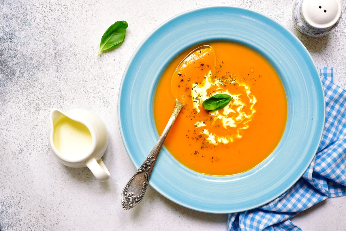 butternut squash soup with cream in a blue bowl