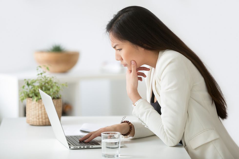 Young professional woman researching a company to determine if she should turn down a job offer.