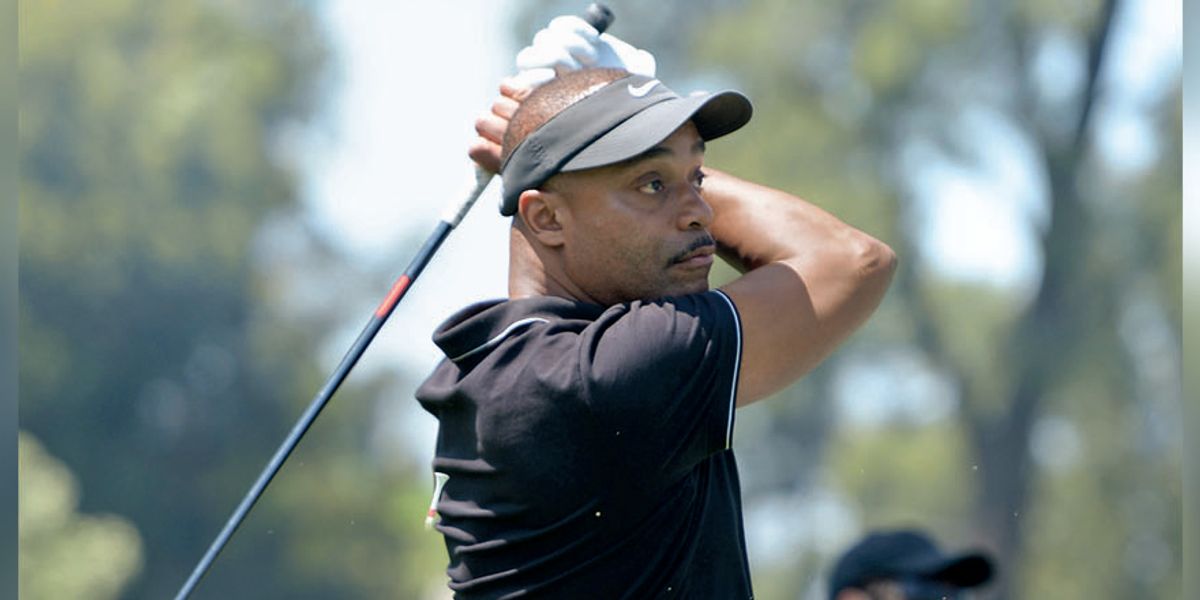 Mid-swing action photo of Rocky Carroll playing golf.