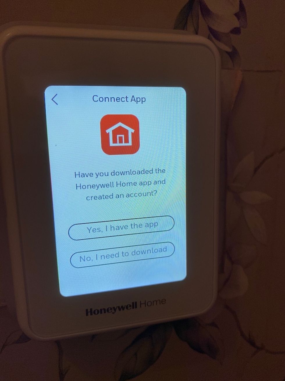 Screen shot of Honeywell Home T9 smart thermostat on the wall with directions on connecting to app.