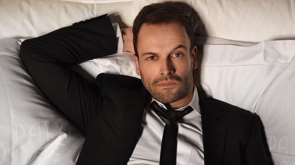 Jonny Lee Miller relaxing on some pillows
