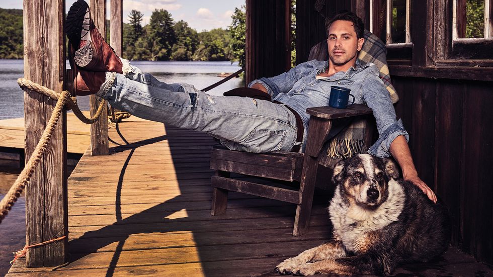 Thomas Sadoski with a dog on a rustic deck