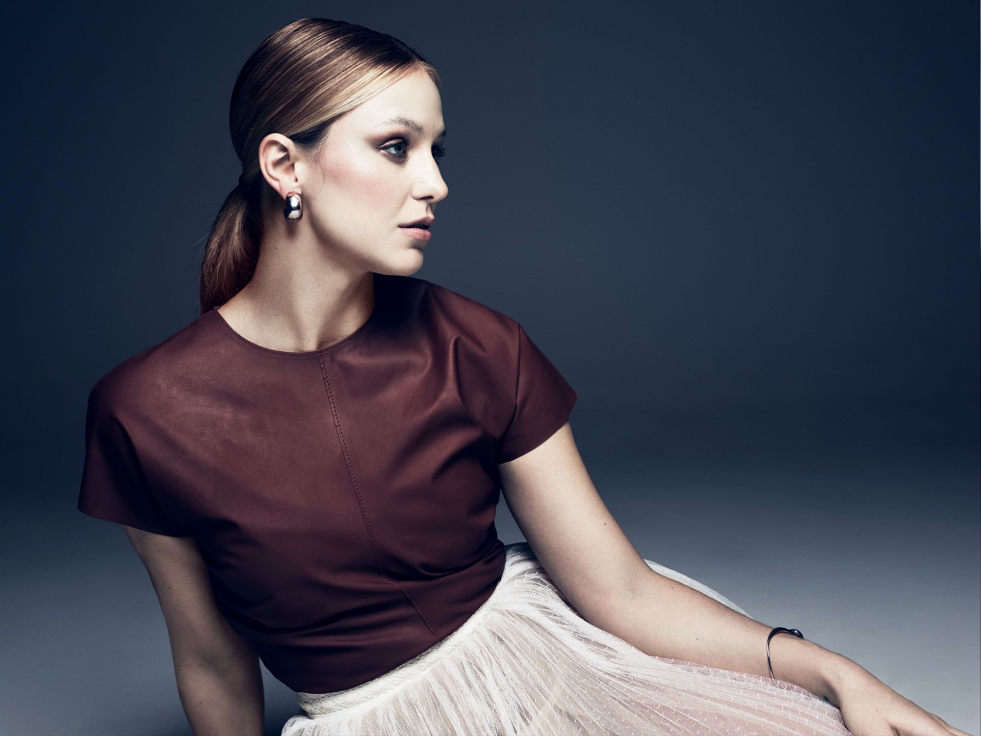 Supergirl's Melissa Benoist wears a purple top and a sheer white transluscent skirt.